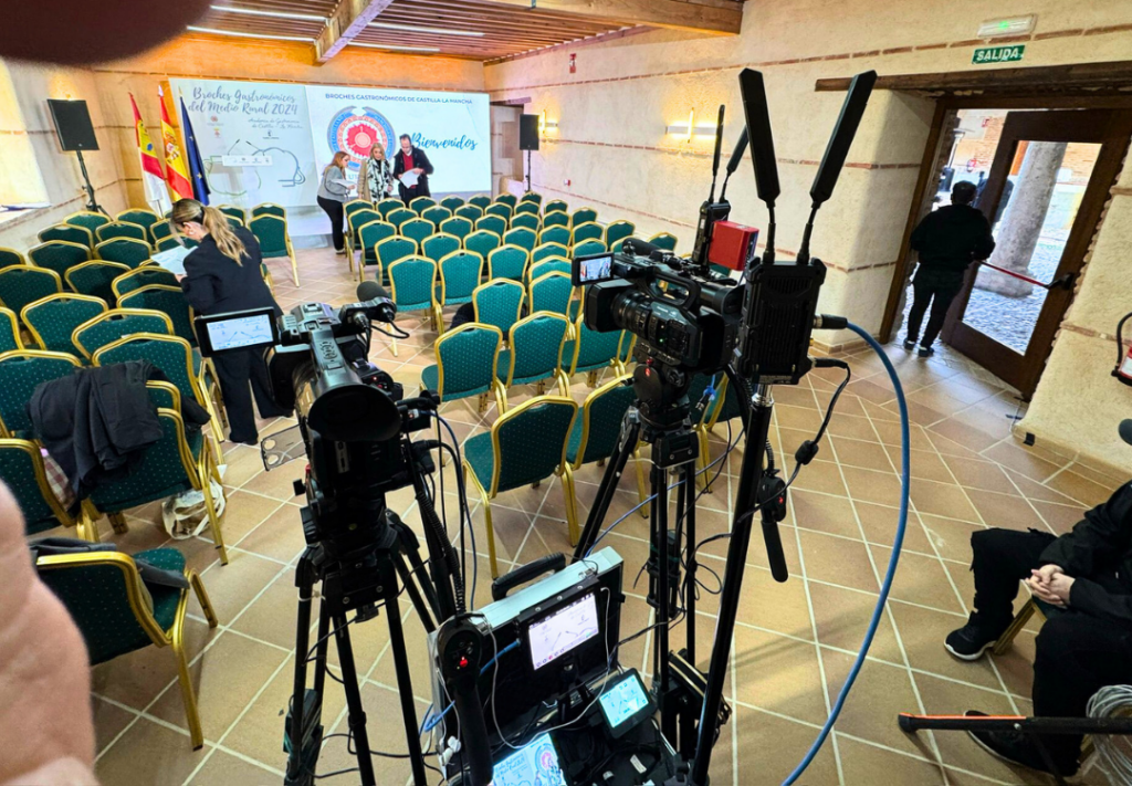 Set de grabación con cámaras profesionales y monitores para un evento.