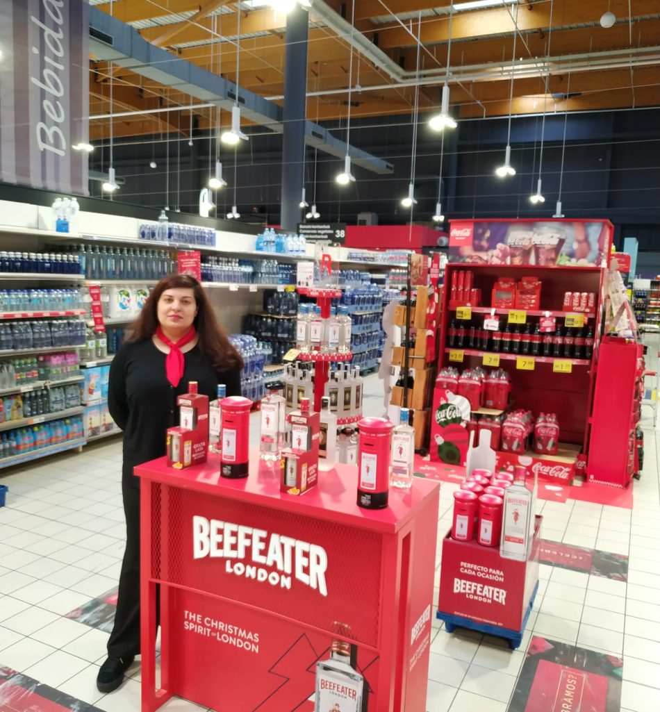 Azafata en el mostrador rojo de ginebra Beefeater.