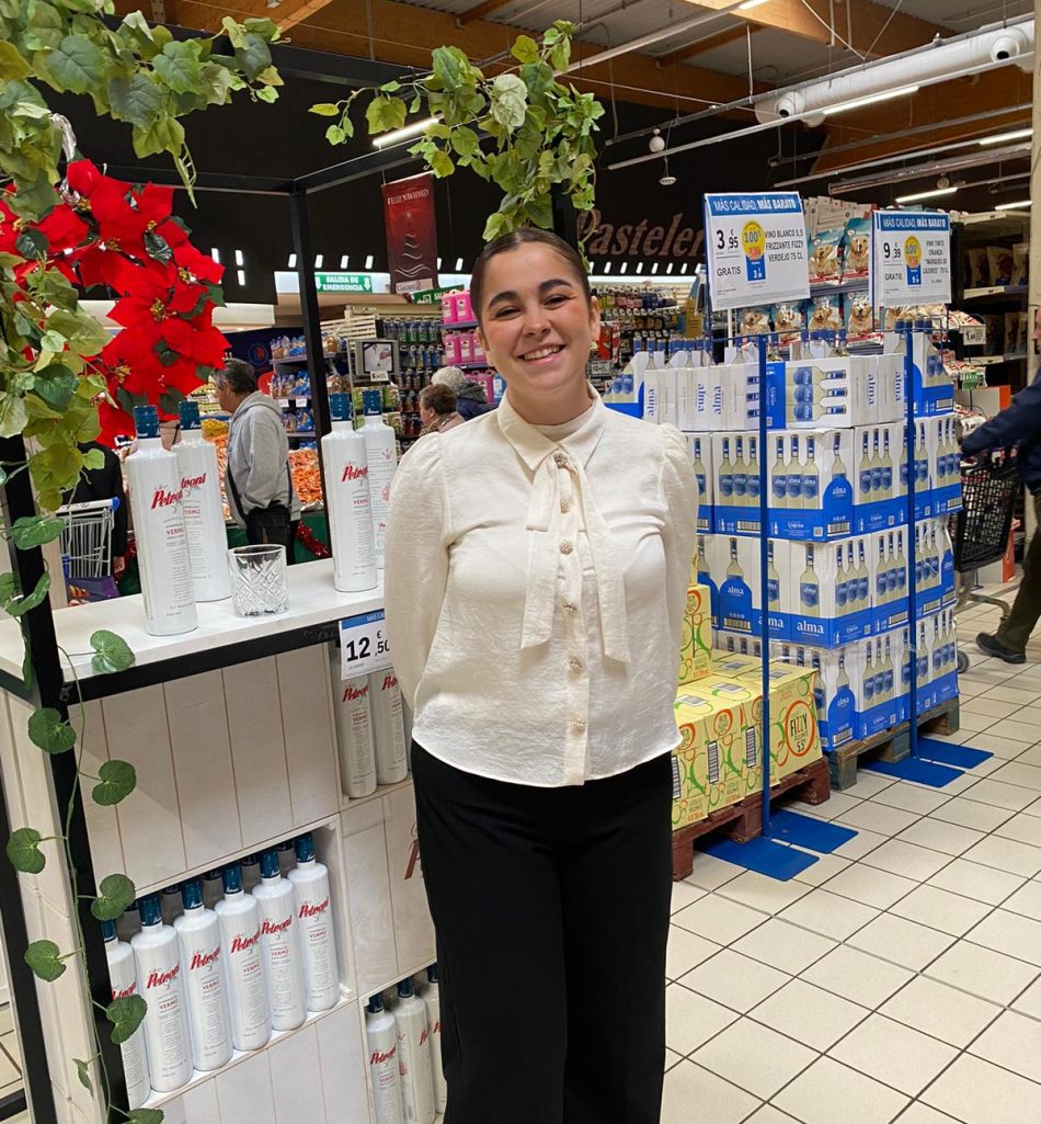 Azafata en un stand de licores con flores.