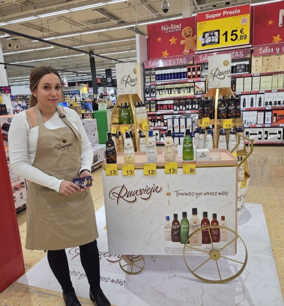 Promotora en stand de licores Ruavieja con carrito clásico.