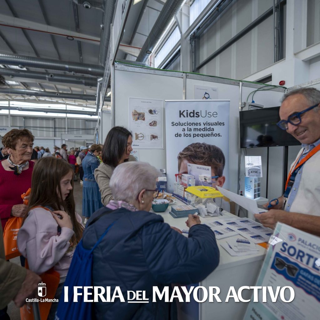 Visitantes consultando información en un stand de la feria.