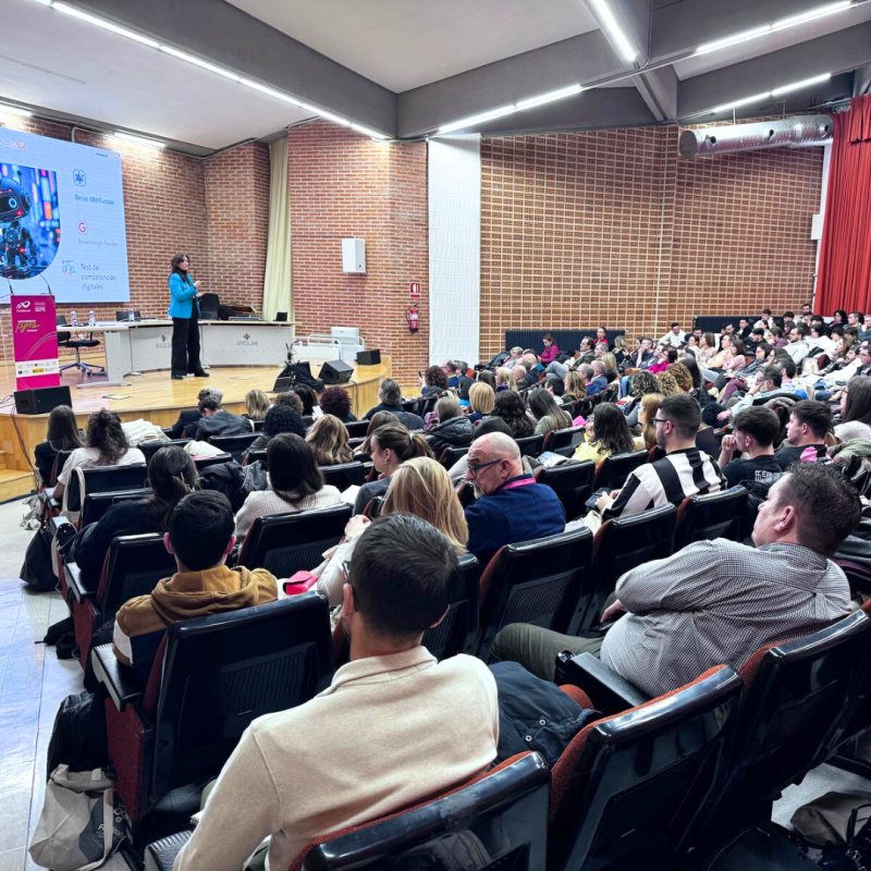 Conferencia en un salón de actos lleno.